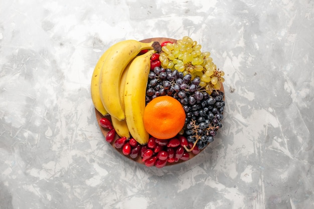 Top view fruit composition fresh bananas dogwoods and grapes on white surface fruit berry freshness vitamine