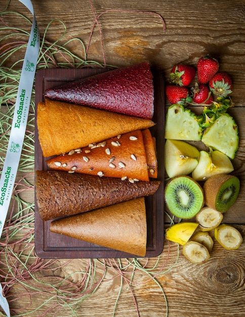 Free photo top view fruit pastila cones on wooden board