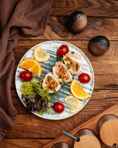 Free photo a top view fruit slices such as orange and lemon inside plate on the brown wooden desk fruit fresh color health