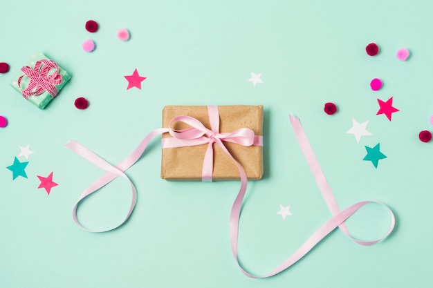 Top view of gift box with pom-poms and stars