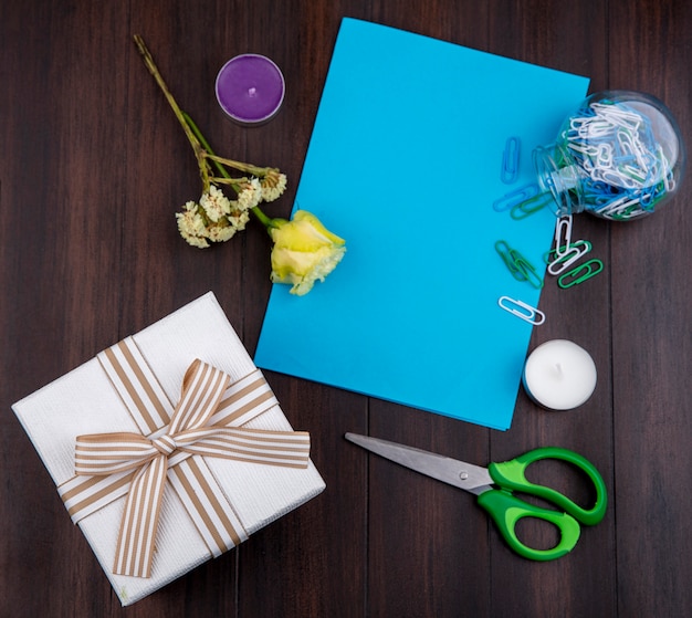 Free photo top view of gift with bow ribbon with yellow rose on a wooden surface with copy space