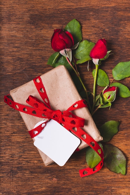 Top view of gift with rose bouquet and tag