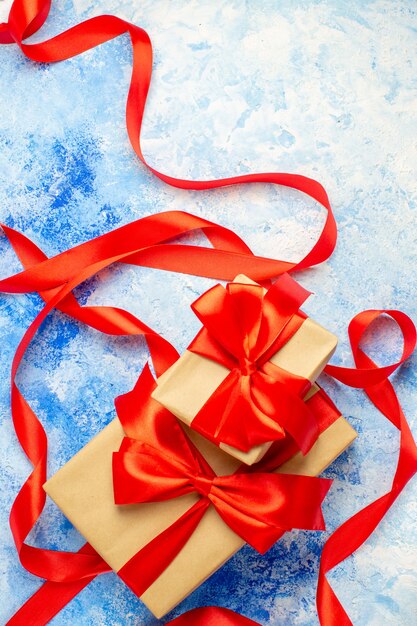 Top view gifts tied with red ribbon on blue white table