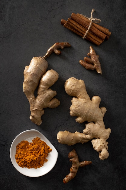 Free photo top view ginger roots with cinnamon sticks