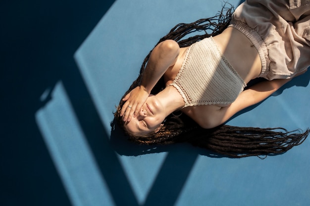 Free photo top view girl with dreadlocks lying on the floor