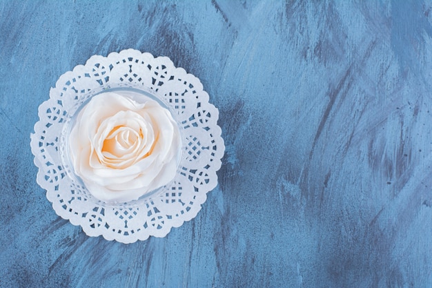 Free photo top view of a glass cup with water and pink rose .