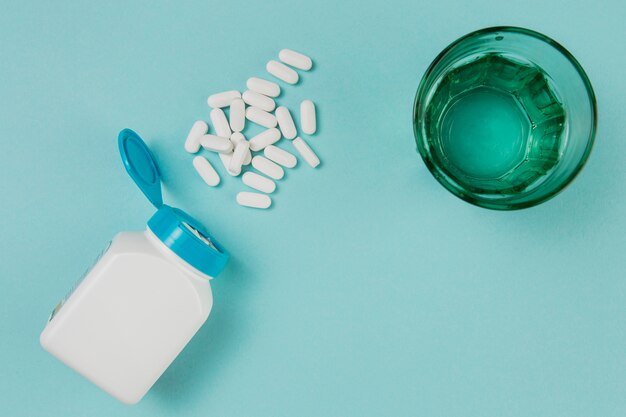 Top view glass with water and medicine on the table