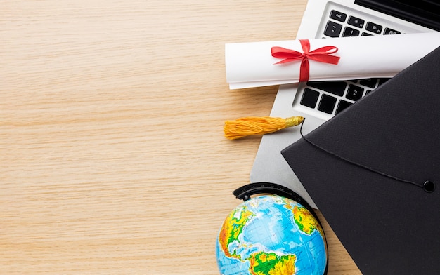 Free Photo top view of globe with academic cap and laptop