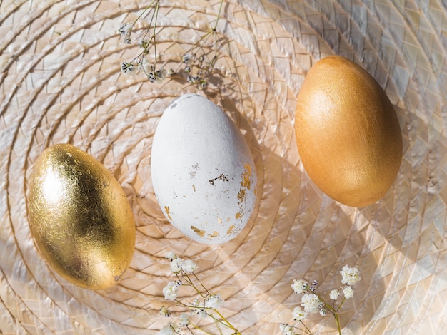 Free photo top view of golden colored easter eggs on placemat