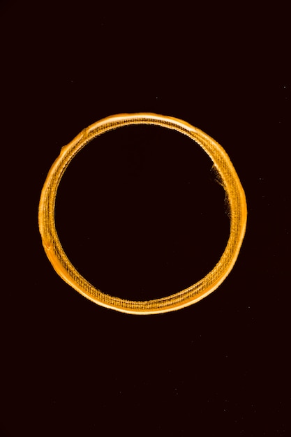 Top view golden melted circle on black background