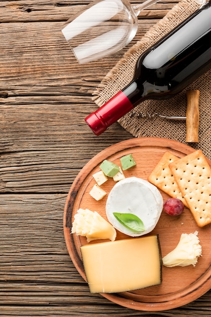 Free photo top view gourmet cheese assortment with wine and glass