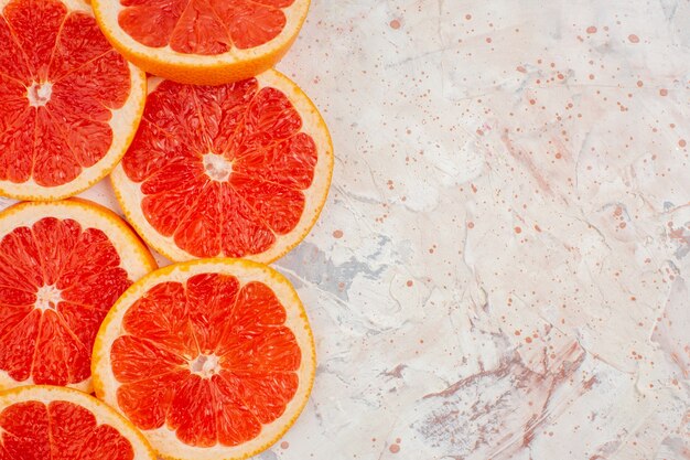 Top view grapefruits slices on nude surface with free space