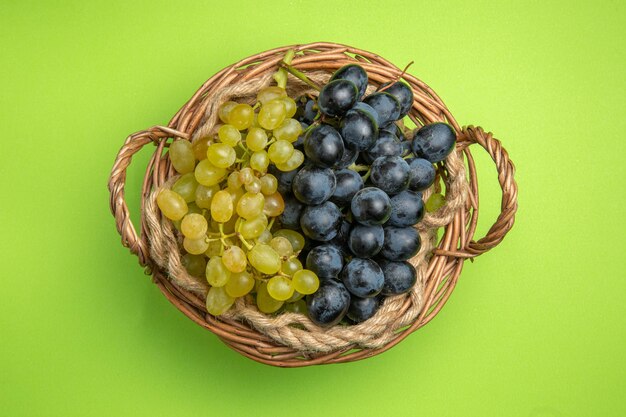 Top view grapes wooden basket of green and black grapes