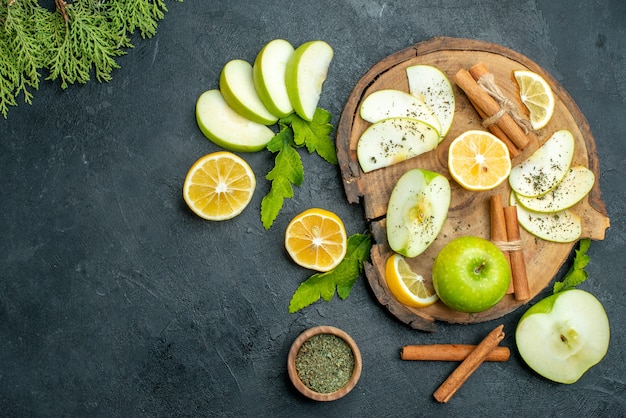 Top view green apples cinnamon sticks and lemon slices apple slices on wood board