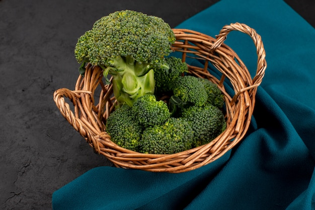 top view green broccoli inside basket on the dark floor