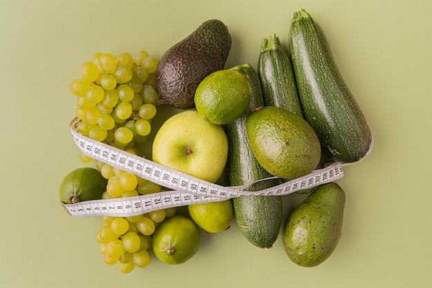 Free Photo top view green fruits and vegetables tied with tape measure