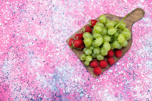 Top view green grapes along with red strawberries on the colored background fruit food vitamine color photo