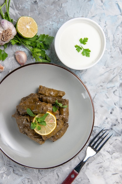 Free Photo top view of green leaf dolma with greens on a white surface