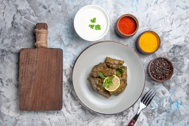 Free Photo top view of green leaf dolma with seasonings on white surface