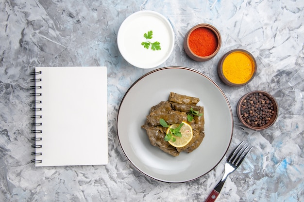 Free Photo top view of green leaf dolma with seasonings on white surface