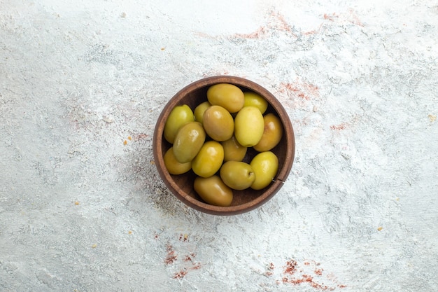 Top view green olives inside little plate on white space