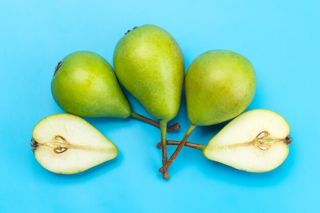 A top view green pears sliced and whole sweet and mellow on blue, fruit juice ripe color