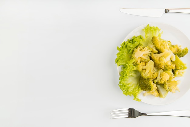 Free Photo top view green salad with cutlery and copy-space