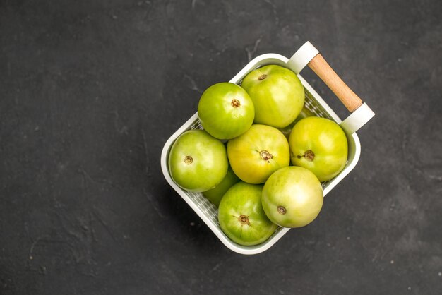 Top view green tomatoes inside basket on dark background photo ripe color fresh food