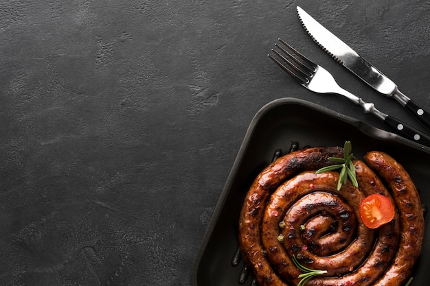 Top view grilled sausage with cutlery on the table