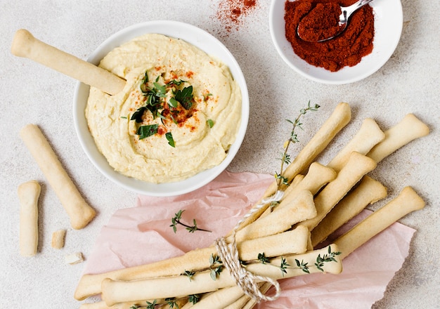 Free photo top view of grissini with hummus and herbs