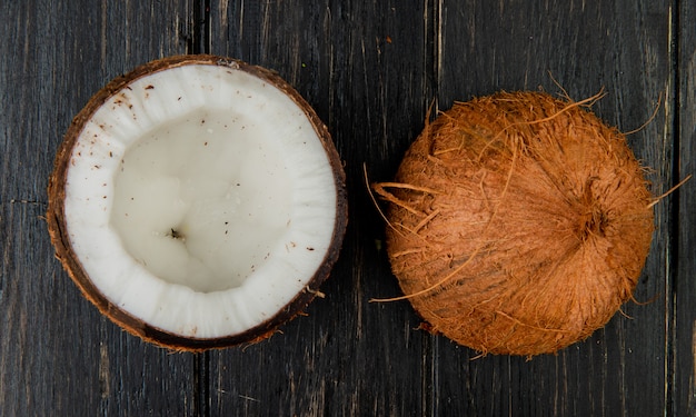 Top view of half cut coconut on wooden background