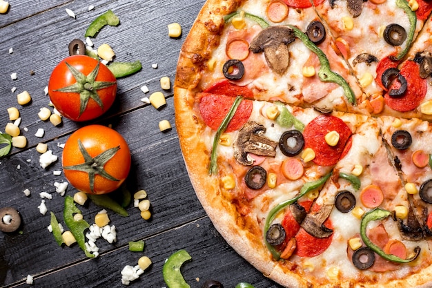 Free photo top view of half of pepperoni pizza placed next to tomato cheese corn and bell pepper