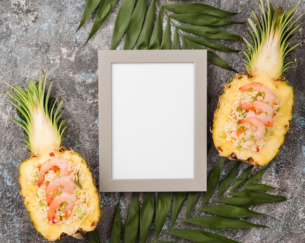 Top view halves of pineapple with empty frame