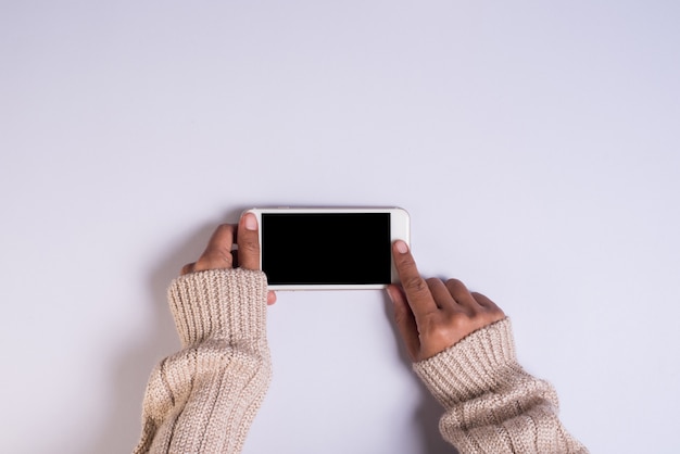 top view hand holding cell phone on white background