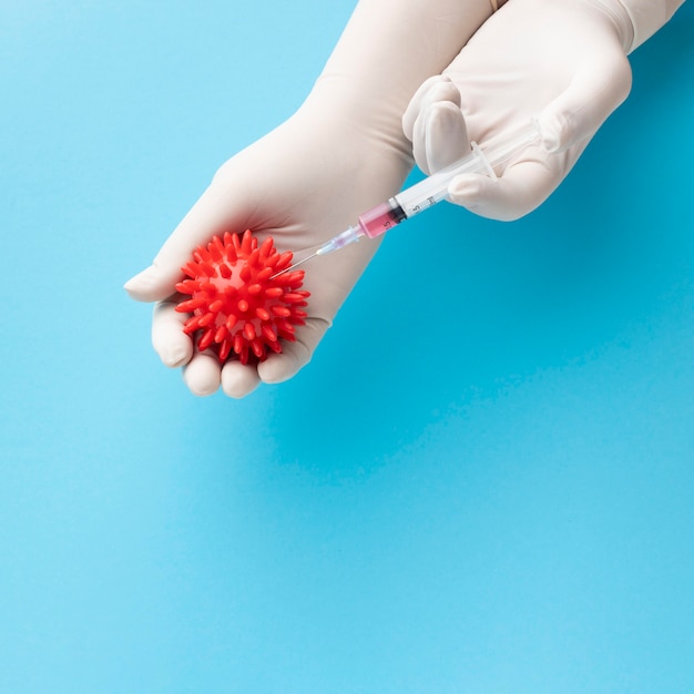 Free photo top view of hand holding virus and syringe with vaccine