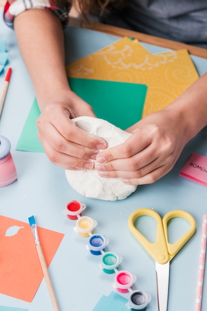 Top view of hand kneading white clay for making creative art