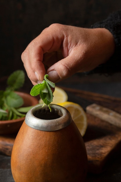 Free photo top view hand putting mint leaves in mug