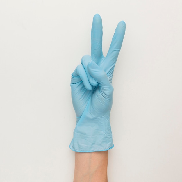 Free photo top view of hand with gloves making peace sign