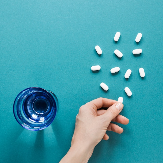 Top view hand with painkillers on the table