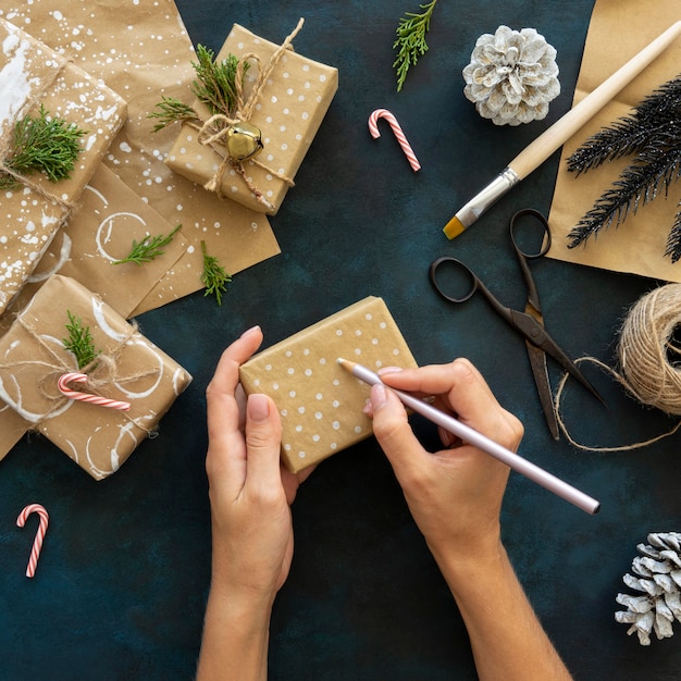 Free Photo top view of hands decorating christmas gift