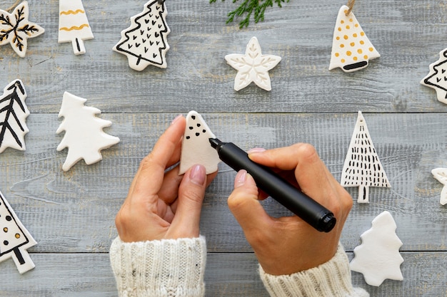 Free photo top view of hands drawing on christmas tree decorations