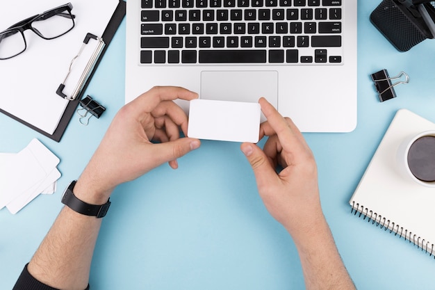 Free photo top view of hands holding business card