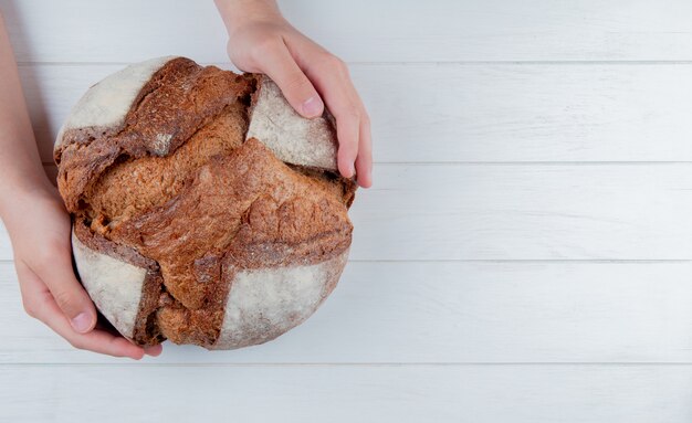 Top view of hands holding cob on wooden background with copy space