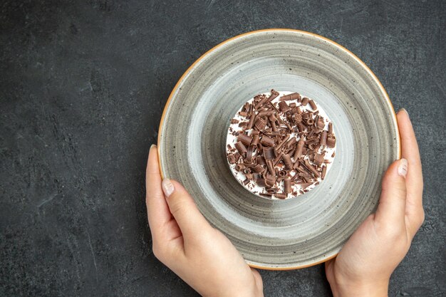 Top view of hands holding delicious creamy homemade cupcake