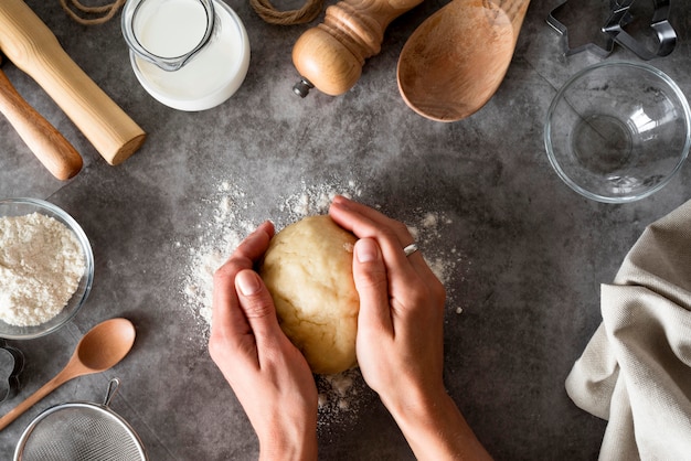 Free photo top view hands holding dough on counter