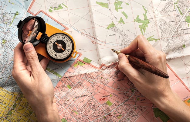 Free photo top view hands holding pencil and compass