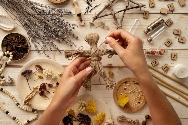 Free photo top view hands holding voodoo doll and needle