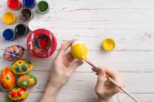 Free photo top view of hands painting an easter egg