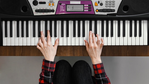 Top view hands playing the digital piano