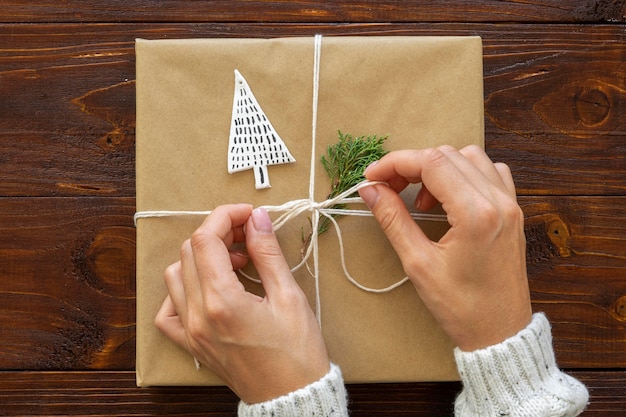 Top view of hands tieing christmas gift